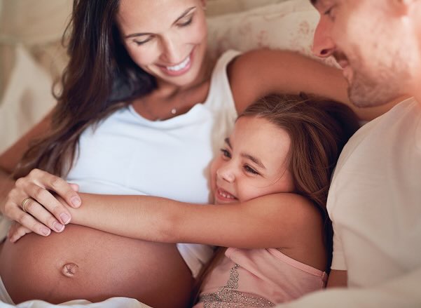Madre embarazada y su hija sonriendo